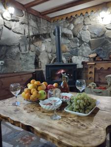 ChokhuldiGuest House Shuan的一张桌子、水果和酒杯以及壁炉
