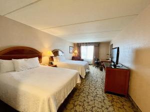休斯顿ACP Hotel Westchase的酒店客房设有两张床和一台平面电视。