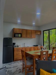 福尔图纳Luxury Villas Arenal的厨房配有桌椅和冰箱。