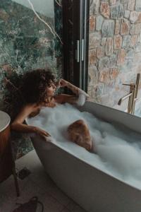 阿齐亚佩拉加快乐克里特公寓式酒店的躺在泡沫浴缸中的女人