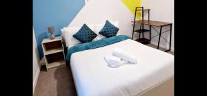 吉林汉姆Beautiful 2-Bed House in Gillingham的卧室配有白色床和蓝色的墙壁
