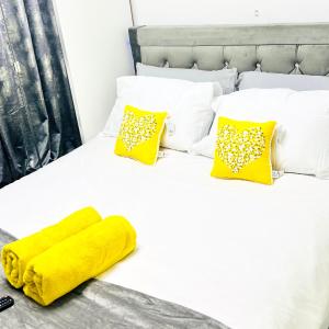 曼彻斯特Private Modern Ensuite Room near Etihad Stadium的一张带黄色毯子和枕头的白色床