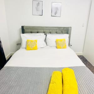 曼彻斯特Private Modern Ensuite Room near Etihad Stadium的一间卧室配有一张带黄色枕头的床