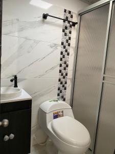 伊瓦格Paraíso House的浴室配有白色卫生间和盥洗盆。