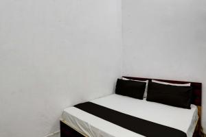 JhājharSuper OYO New River View的白色客房 - 带2个黑色枕头的床