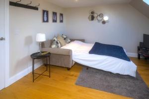 布罗肯赫斯特Entire Apartment in Central Brockenhurst的一间卧室配有一张床、一张沙发和一张桌子