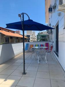 弗洛里亚诺波利斯Residencial Ametista - 250 metros do mar的阳台配有桌椅和遮阳伞