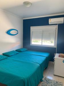 弗洛里亚诺波利斯Residencial Ametista - 250 metros do mar的一间蓝色卧室,配有两张床和窗户