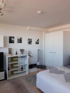 菲尔特Appartement mit Penthaus Charakter的白色卧室配有床和冰箱