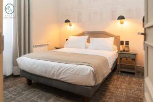蓬塔阿雷纳斯何塞·诺盖拉酒店的卧室配有一张带白色床单和枕头的大床。