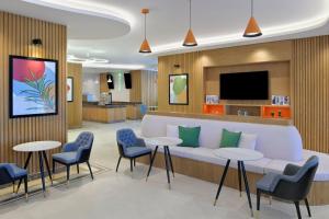 吉达Holiday Inn Jeddah Corniche, an IHG Hotel的一间配有沙发、椅子和电视的等候室