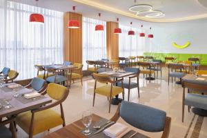 吉达Holiday Inn Jeddah Corniche, an IHG Hotel的餐厅设有桌椅和窗户。