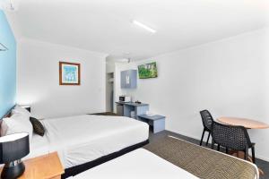 洛甘利沃特福德伊克诺旅馆的酒店客房设有两张床和一张桌子。