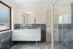洛甘利沃特福德伊克诺旅馆的浴室配有白色水槽和淋浴。
