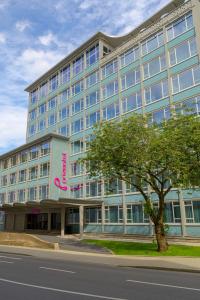 多特蒙德prizeotel Dortmund-City的一座蓝色的大建筑,上面有粉红色的标志