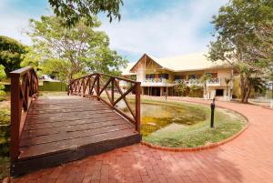 奇特雷Hotel Faranda Guayacanes, a member of Radisson Individuals的一座建在一座建筑前面的池塘上的木桥