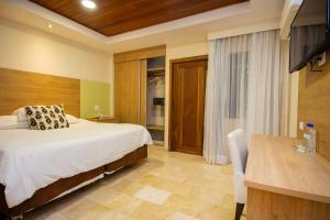 奇特雷Hotel Faranda Guayacanes, a member of Radisson Individuals的一间卧室配有一张床、一张桌子和一张桌子