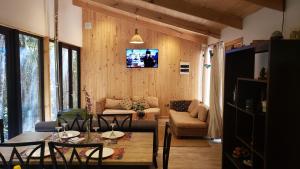 巴拉斯港Cabaña Bosque Rio的客厅配有桌子和墙上的电视