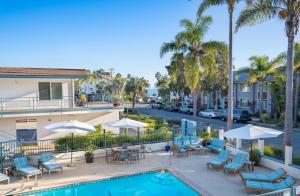 圣巴巴拉圣巴巴拉太平洋克里斯特酒店的一座带椅子和遮阳伞的游泳池位于一座建筑旁边