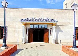 帕洛斯德拉夫龙特拉Hotel Puerto de Palos (La Rabida)的一座大型砖砌建筑,设有大门