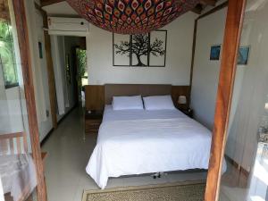 乌巴图巴Chalé e Suite Manacá的卧室配有白色床和吊灯