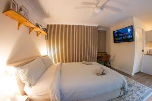 Tanah MerahAlina's Peaceful Studio的卧室配有白色的床,墙上配有电视