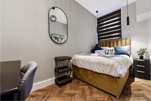 伦敦Lovely 2 BR with Grill的一间卧室配有一张带镜子和椅子的床