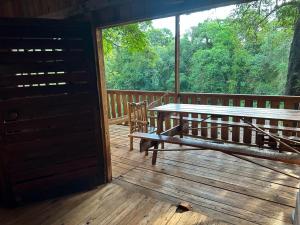 美洲花园La Virginia Rancho Tabay的木甲板上设有木门廊和长凳