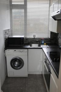 埃德蒙顿2 bedroom apartment with balcony near Tottenham Hostpur Stadium的厨房配有洗衣机和水槽