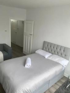 埃德蒙顿2 bedroom apartment with balcony near Tottenham Hostpur Stadium的卧室配有白色的床和椅子