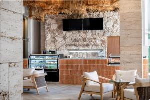 坎昆Seadust Cancun Family Resort - All Inclusive的餐厅设有酒吧,墙上配有电视。