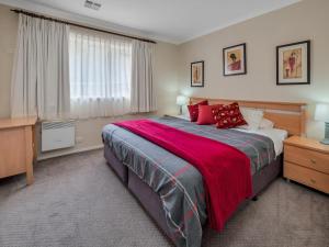 金德拜恩Wanderers Retreat的一间卧室配有一张带红色枕头的大床