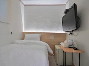 首尔J5 Hostel的一间卧室配有一张床和一台平面电视