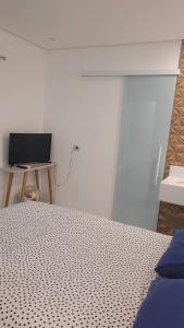 伯迪亚哥Studio 01的一间卧室配有一张床和一张书桌及电视
