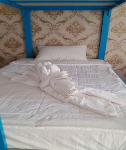 潘切Nu Cuoi Mui Ne Hotel & Restaurant的一张带白色床单和蓝色床头板的床