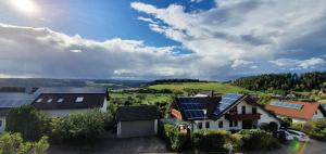 Kleine Blockhütte im Garten的一组屋顶上设有太阳能电池板的房屋