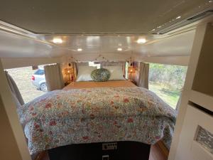FaradayBUS - Tiny home - 1980s classic with off grid elegance的露营车后面的卧室,配有一张床