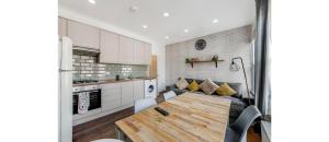 伦敦Spacious Two Bedroom Apartment in Wood Green的厨房以及带桌子和沙发的客厅。