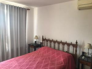 维拉卡洛斯帕兹Carlos Paz, Villa Santa Cruz del Lago的一间卧室配有一张红色床罩的床