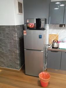 云顶高原10Pax Deluxe Apartment , CloudView Snoopy Theme, Amber Court, Genting Highlands的厨房配有冰箱上方的微波炉