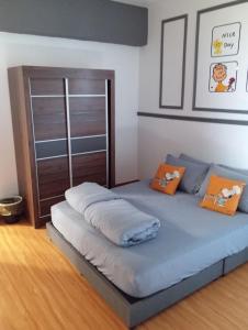 云顶高原10Pax Deluxe Apartment , CloudView Snoopy Theme, Amber Court, Genting Highlands的一间卧室配有带橙色枕头的床