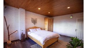 大叻Scent Village Hotel的卧室设有一张砖墙内的大床