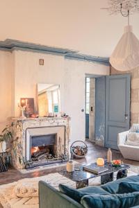Vertheuil-en-MédocLa Nuit & Le Jour的客厅设有壁炉和沙发。
