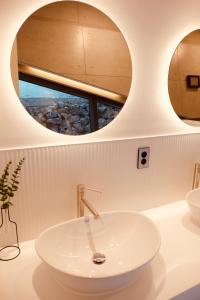 济州市米尔旅舍的浴室设有水槽和2个圆形镜子