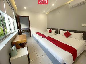 头顿VND Vũng Tàu Hotel & Villa的酒店客房设有两张床和窗户。