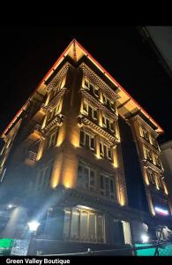帕罗Green valley boutique的一座高大的建筑,晚上有灯