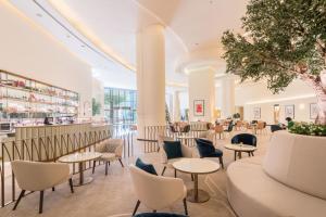 迪拜JW Marriott Hotel Marina的大堂设有桌椅和酒吧。