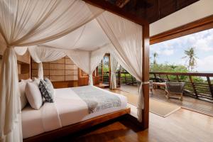 BalianThe Cove Bali by Nakula的一间卧室设有一张天蓬床和一个甲板。