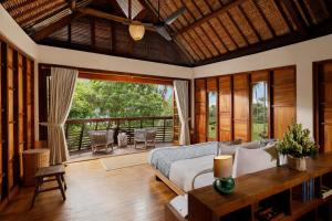 BalianThe Cove Bali by Nakula的一间卧室设有一张床和一个阳台