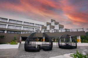 龙目岛库塔Raja Hotel Kuta Mandalika Resort & Convention的一座有云天的建筑